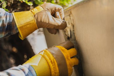 Eldivenli bir işçi merdivenlerin seramik fayanslarını söker.