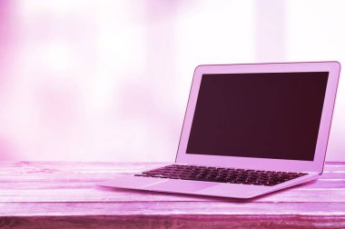 Renkli parlak neon ve mor ışıklarda boş ekranlı ince modern laptop.