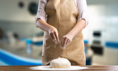 Önlük giymiş olgun bir kadın ekmek pişiriyor ya da evdeki sıcak mutfakta turta yapıyor..