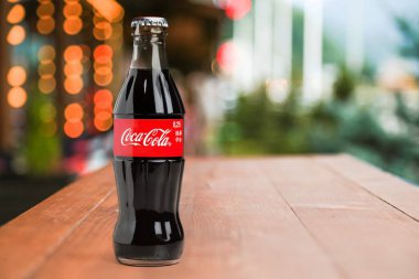 Soğuk klasik Coca-Cola şişesi ahşap masada.