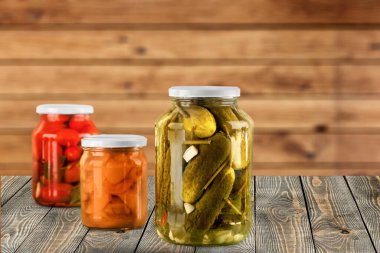 Salatalık turşulu cam kavanozlar, domates ve lahana. Kırsal bir kompozisyonda konserve yiyecekler.