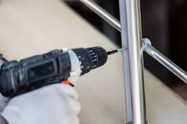 Ein Arbeiter Handschuhen Repariert Mit Einem Schraubenzieher Und Einem Bohrer — Stockfoto