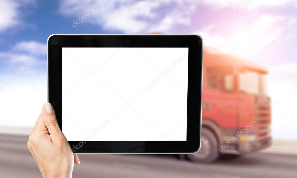Manager with a blank screen digital tablet on the background of trucks.