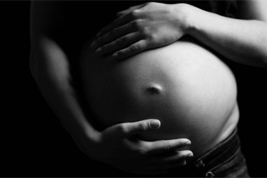 Siyah beyaz fotoğraflı hamile bir kadın.