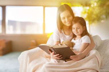 Anne kızına okumayı öğretiyor.