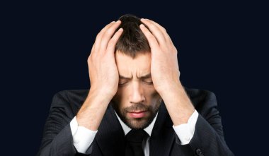 İyi giyimli, başı bağlı, sorunlu, olgun bir adam.