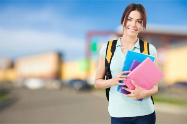 Kitapları ve okul çantasıyla gülümseyen öğrencinin parlak resmi