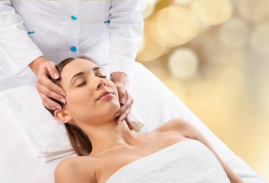 Kaplıca salonundaki genç kadın masaj tedavisi görüyor.