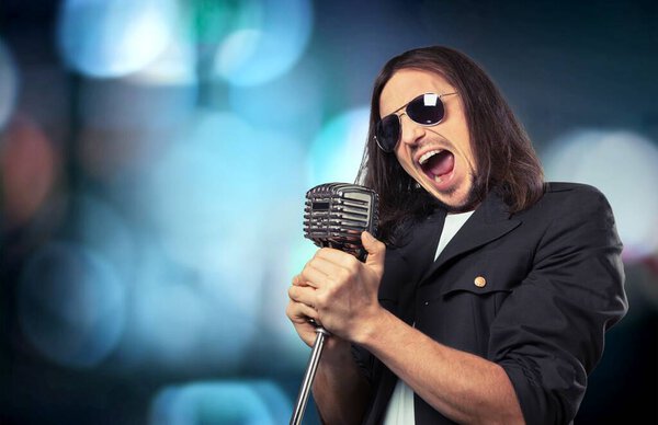  young man with a microphone on the background 