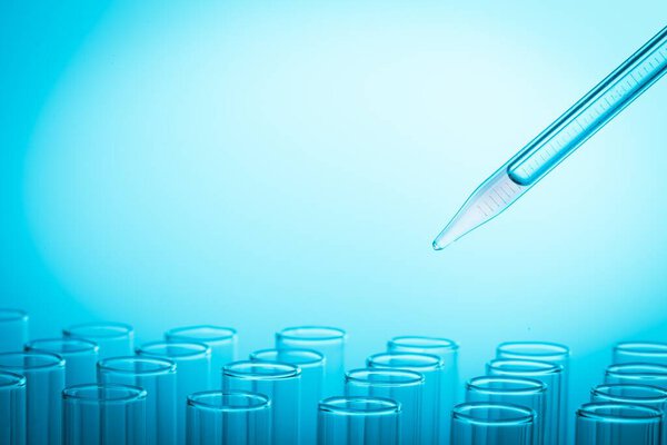 laboratory glassware with blue liquid in the background