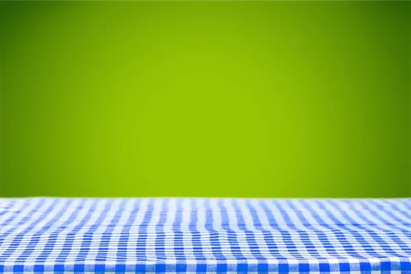 机の上に青いチェックの布ナプキン — ストック写真