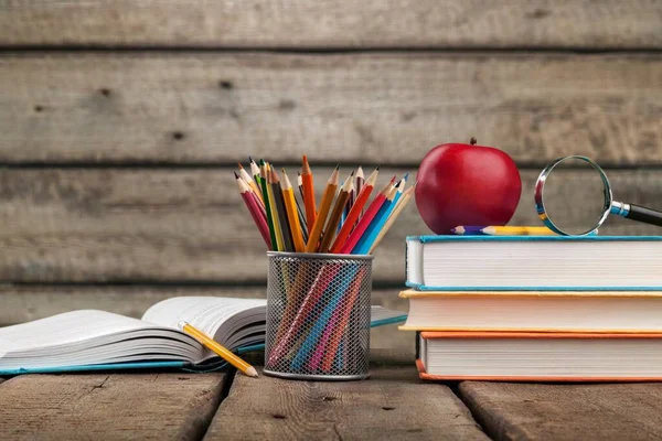 色彩艳丽的铅笔 红色的苹果和一堆堆木制背景的书 学校概念 — 图库照片