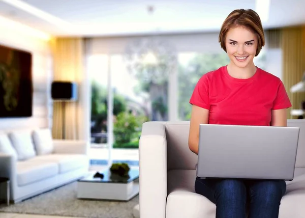 Junge Frau Sitzt Mit Laptop Auf Sofa Und Lächelt Die — Stockfoto