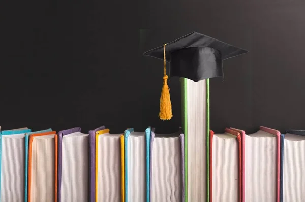 Colección Libros Con Sombrero Graduación Sobre Fondo Oscuro —  Fotos de Stock