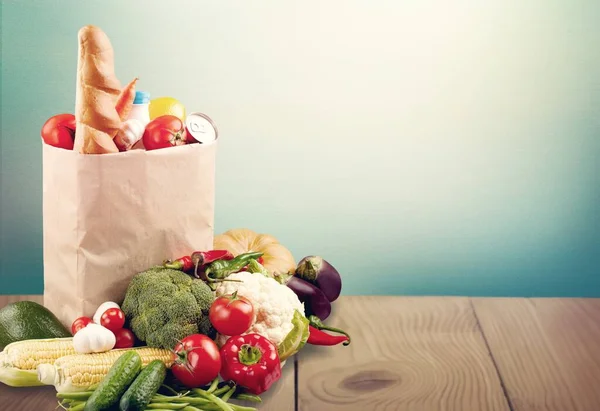 fresh vegetables in a bag on a wooden background.