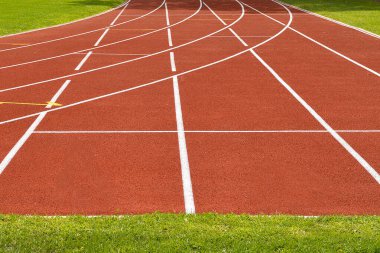 Tartan atletizm pisti etrafında çimen ve birkaç şeritle başlar.