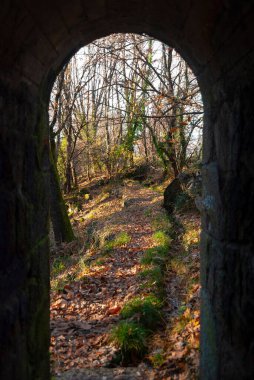 Arka planda sonbahar manzaralı dar taş geçit tüneli