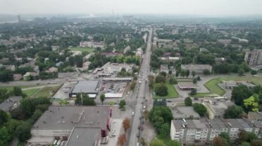 Küçük bir kasabanın havadan görünüşü, şehir manzarası, Yeşil Alanlar yakınlarındaki evlerin yanından uçmak.