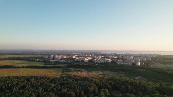 Вид с воздуха Малый город с высокими зданиями в окружении зеленой растительности — стоковое видео