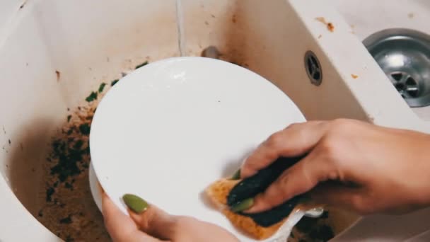 Mujer joven lava los platos en el fregadero sucio en la cocina casera, cámara lenta — Vídeos de Stock