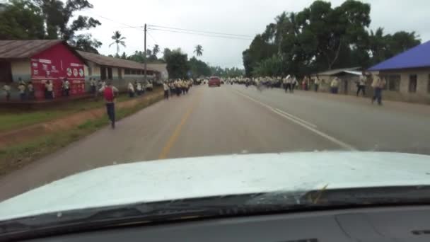 Folle di bambini delle scuole africane corrono fuori su strada nel villaggio locale, guidando auto, Zanzibar — Video Stock