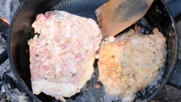 Τηγανητό χοιρινό κομμάτια σε λάδι σε ένα τηγάνι τηγανίσματος πάνω από τη φωτιά Εξωτερική, μαγείρεμα λίπος κρέατος — Αρχείο Βίντεο