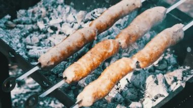 Sosisler portatif ızgarada pişiriliyor. Kapatın, barbekü.