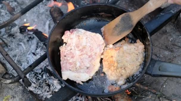 Τηγανητό χοιρινό κομμάτια σε λάδι σε ένα τηγάνι τηγανίσματος πάνω από τη φωτιά Εξωτερική, μαγείρεμα λίπος κρέατος — Αρχείο Βίντεο