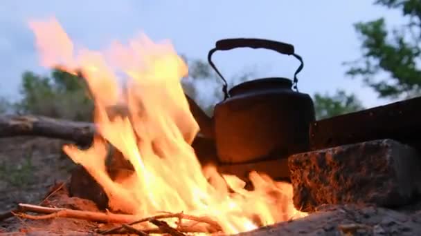 Alter Touristenkessel steht in der Dämmerung mit Flammen am Lagerfeuer — Stockvideo