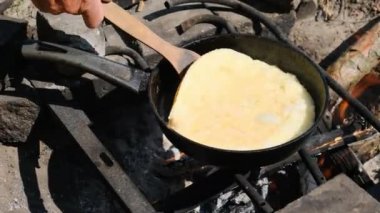 Doğada Turist Kızartma Tavasında Kamp ateşinde omlet pişirmek