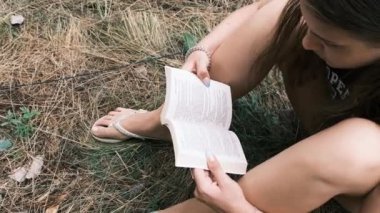 Genç Kadın, Yaz Gününde Doğada Çimlerin Üzerinde Oturan Bir Kitap Okuyor