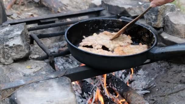 Tocuri de porc prăjite în ulei într-o tigaie de prăjit peste foc în aer liber, gătit carne grasă — Videoclip de stoc