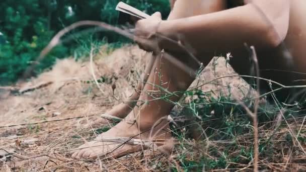 Genç Kadın, Yaz Gününde Doğada Çimlerin Üzerinde Oturan Bir Kitap Okuyor — Stok video