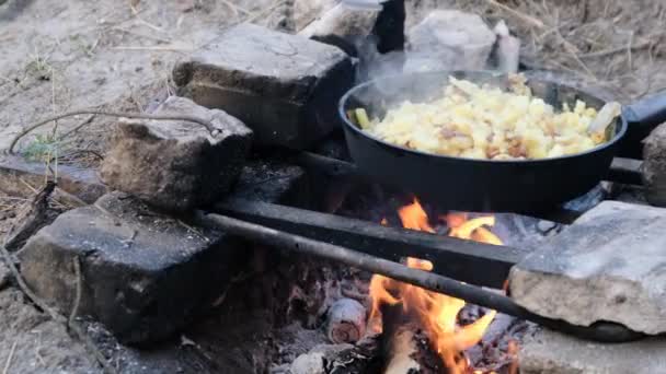 Τηγανητές πατάτες μαγειρεύουν στο τηγάνι πάνω από μια φωτιά Εξωτερική σε αυτοσχέδια κουζίνα — Αρχείο Βίντεο