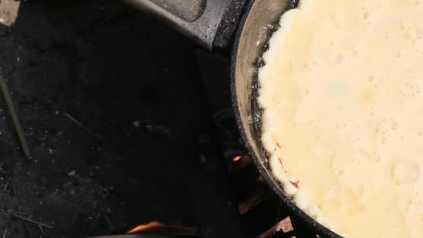 Koken van een Omelet op een kampvuur in een toeristische koekenpan in de natuur, slow motion — Stockvideo
