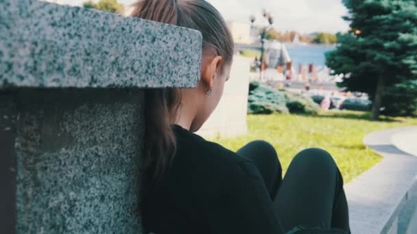 Fiatal nő használja okostelefon, miközben ül a parapet a Street Park — Stock videók