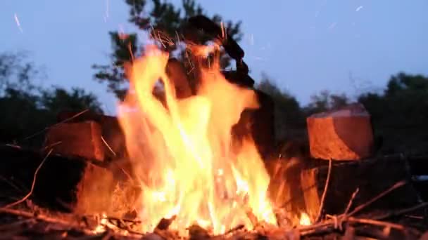 Alter Touristenkessel steht in der Dämmerung mit Flammen am Lagerfeuer — Stockvideo