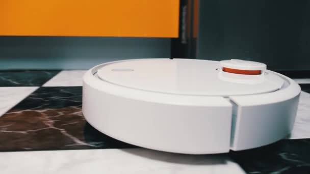 La aspiradora Robot limpia en la casa moderna en el piso de baldosas en la cocina — Vídeos de Stock