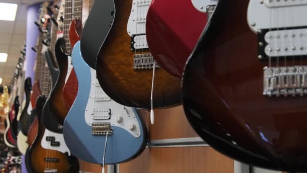 Many New Different Multicolored Electric Guitars are Sold in the Store — Stockvideo