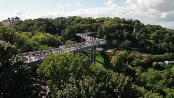 Zicht vanuit de lucht op de glazen voetgangersbrug met een menigte wandelende mensen — Stockvideo