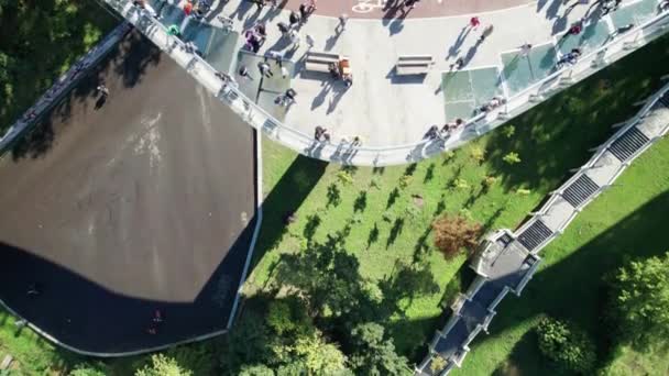 Bovenaanzicht vanuit de lucht van de glazen voetgangersbrug met een menigte wandelende mensen — Stockvideo