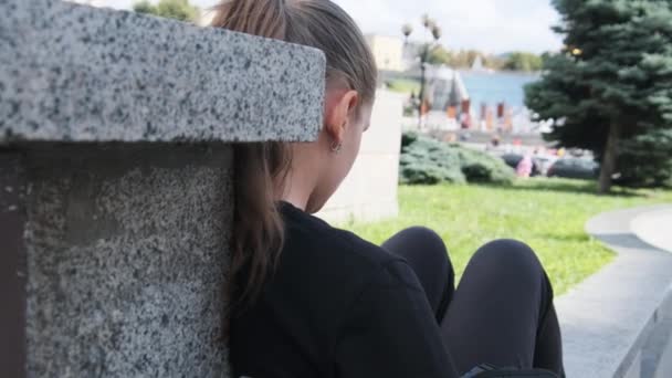 Young Woman Uses Smartphone While Sitting on the Parapet in the Street Park — Video Stock