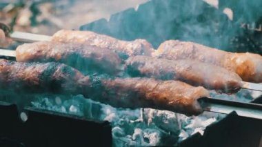 Sosisler portatif ızgarada pişiriliyor. Kapatın, barbekü.
