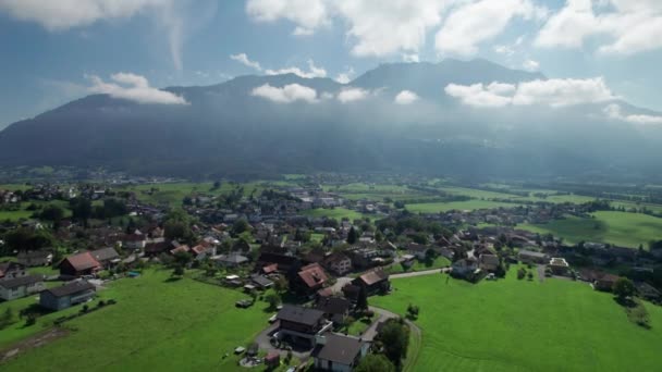 Widok z lotu ptaka na Liechtenstein z domami na zielonych polach w Alpach Mountain Valley — Wideo stockowe