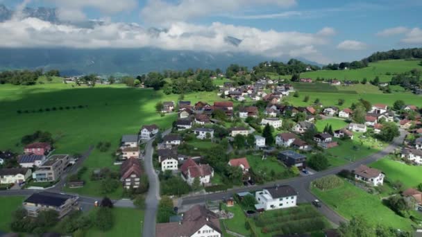 Vista aérea de Liechtenstein con casas en campos verdes en Alpes Mountain Valley — Vídeos de Stock