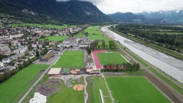 Liechtenstein con Casas en Campos Verdes en Alpes Mountain Valley, Vista Aérea — Vídeos de Stock