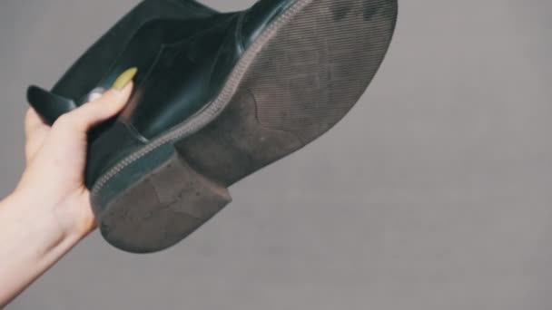 La suela del zapato habla divertido, la mano femenina sostiene una bota con una suela arrancada — Vídeo de stock