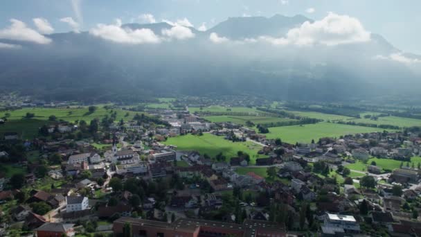 Flygfoto över Liechtenstein med hus på gröna fält i Alperna Mountain Valley — Stockvideo