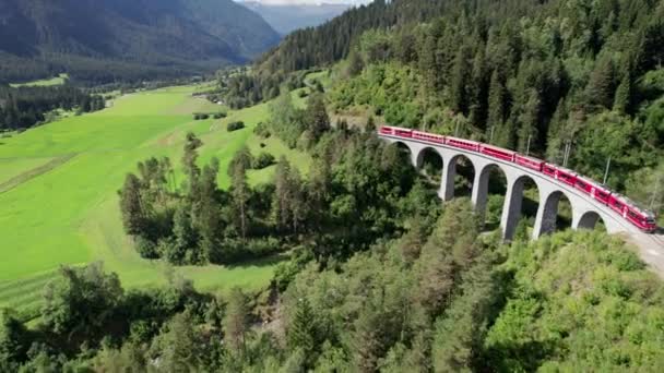 Vista aérea de um trem vermelho em movimento ao longo do Viaduto Landwasser em Alpes Suíços — Vídeo de Stock