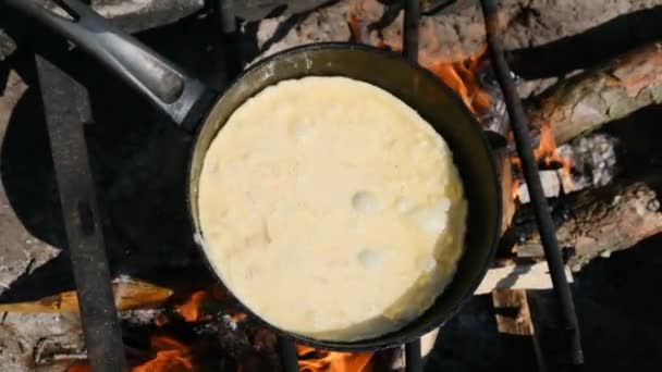 Koken van een Omelet op een kampvuur in een toeristische koekenpan in de natuur, slow motion — Stockvideo